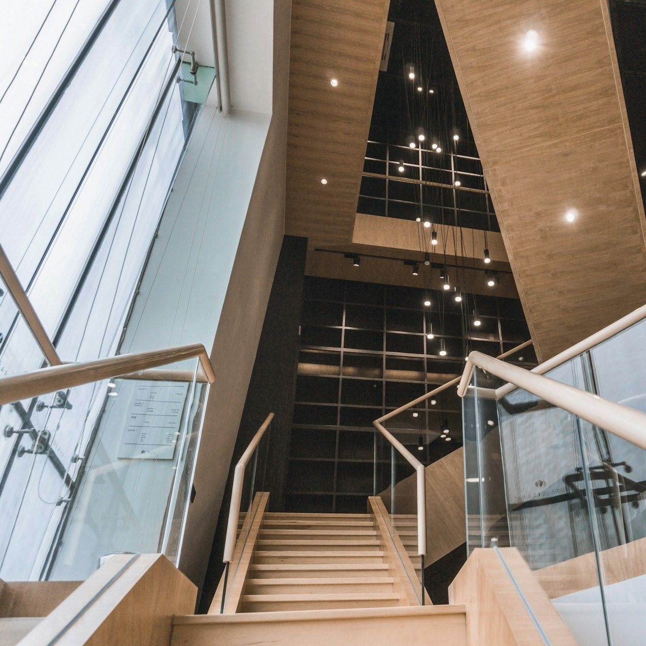 Wooden staircase with glass railings in a modern commercial building
