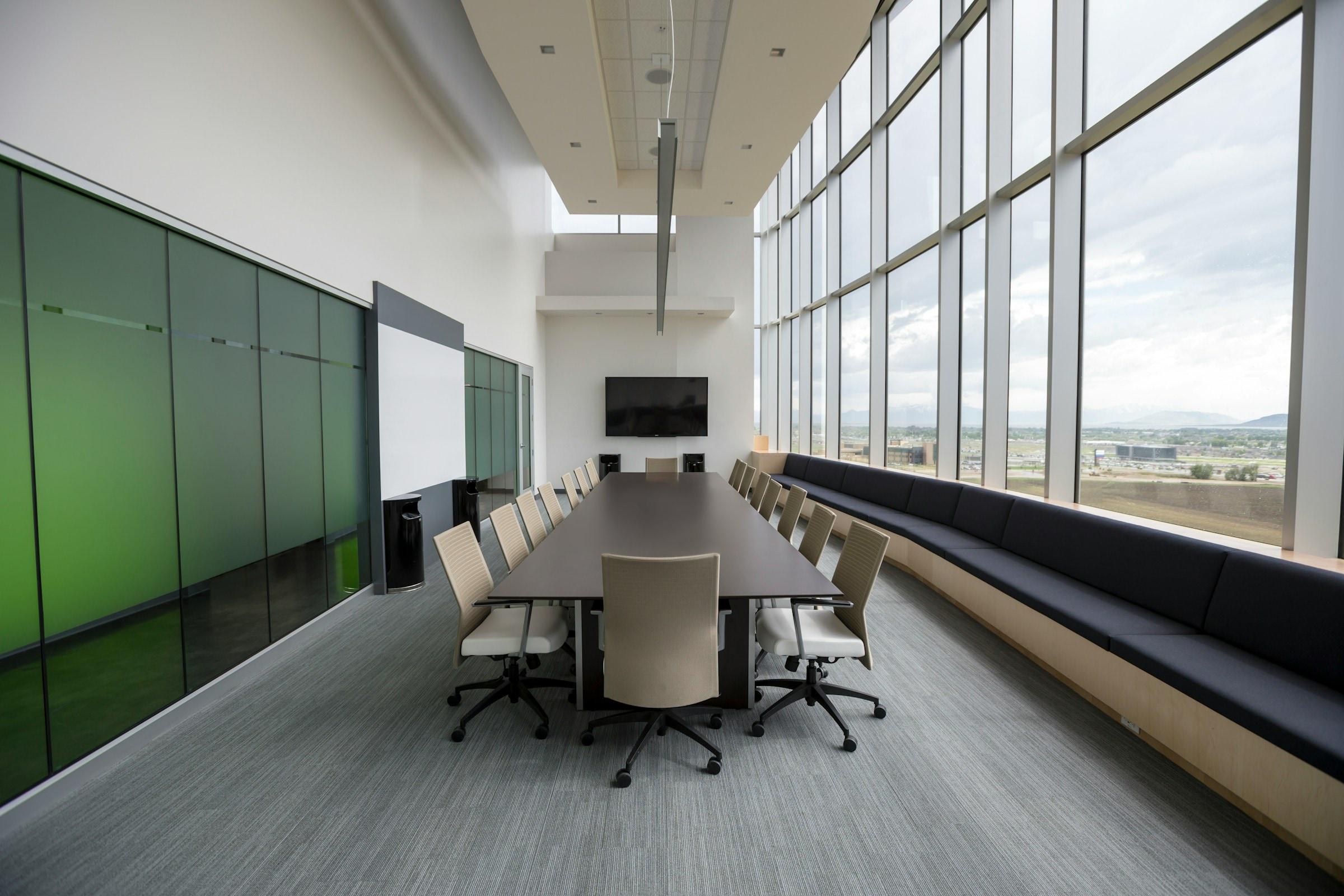 Corporate boardroom with a long table and floor-to-ceiling windows