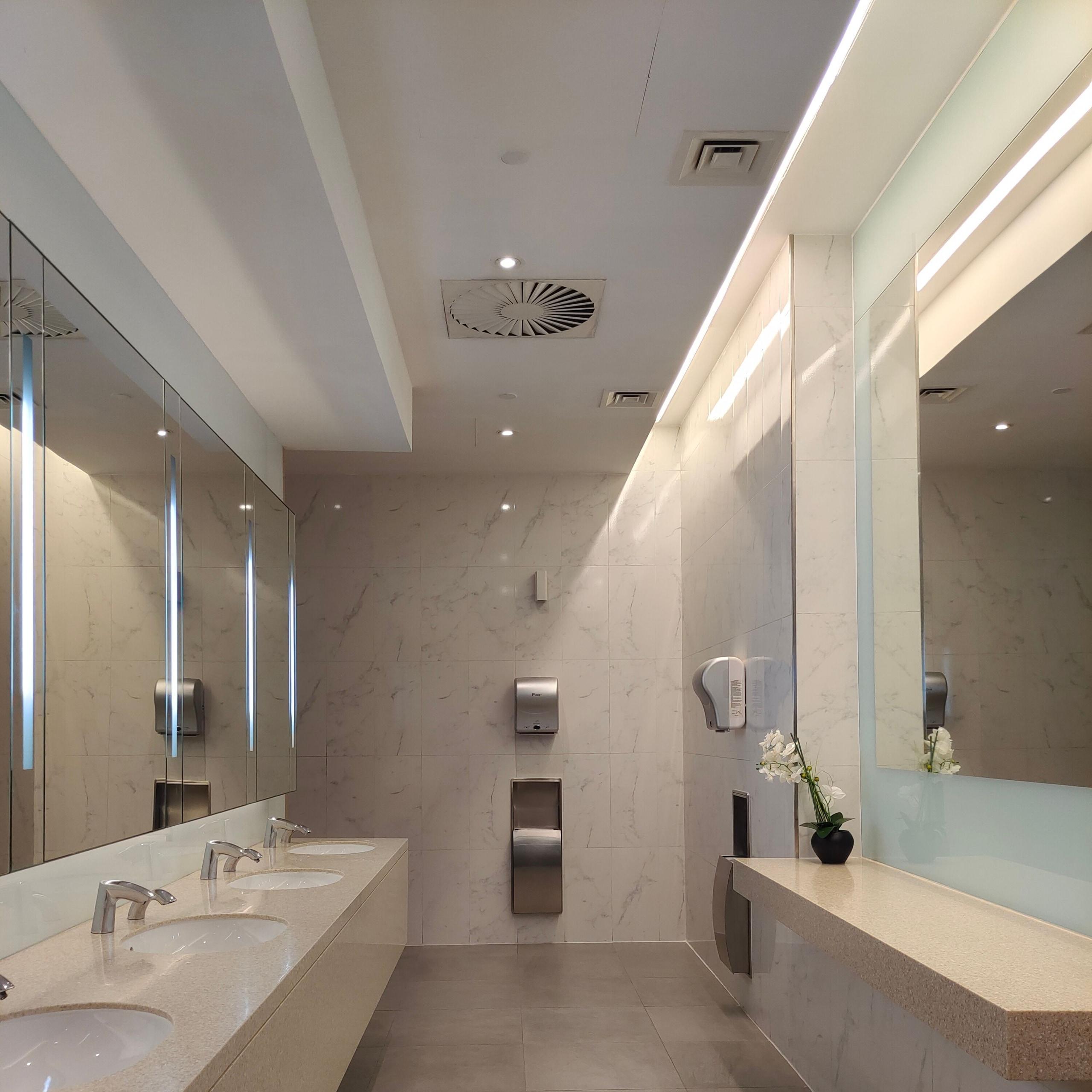 Commercial restroom vanity with twin basins and full-width mirrors