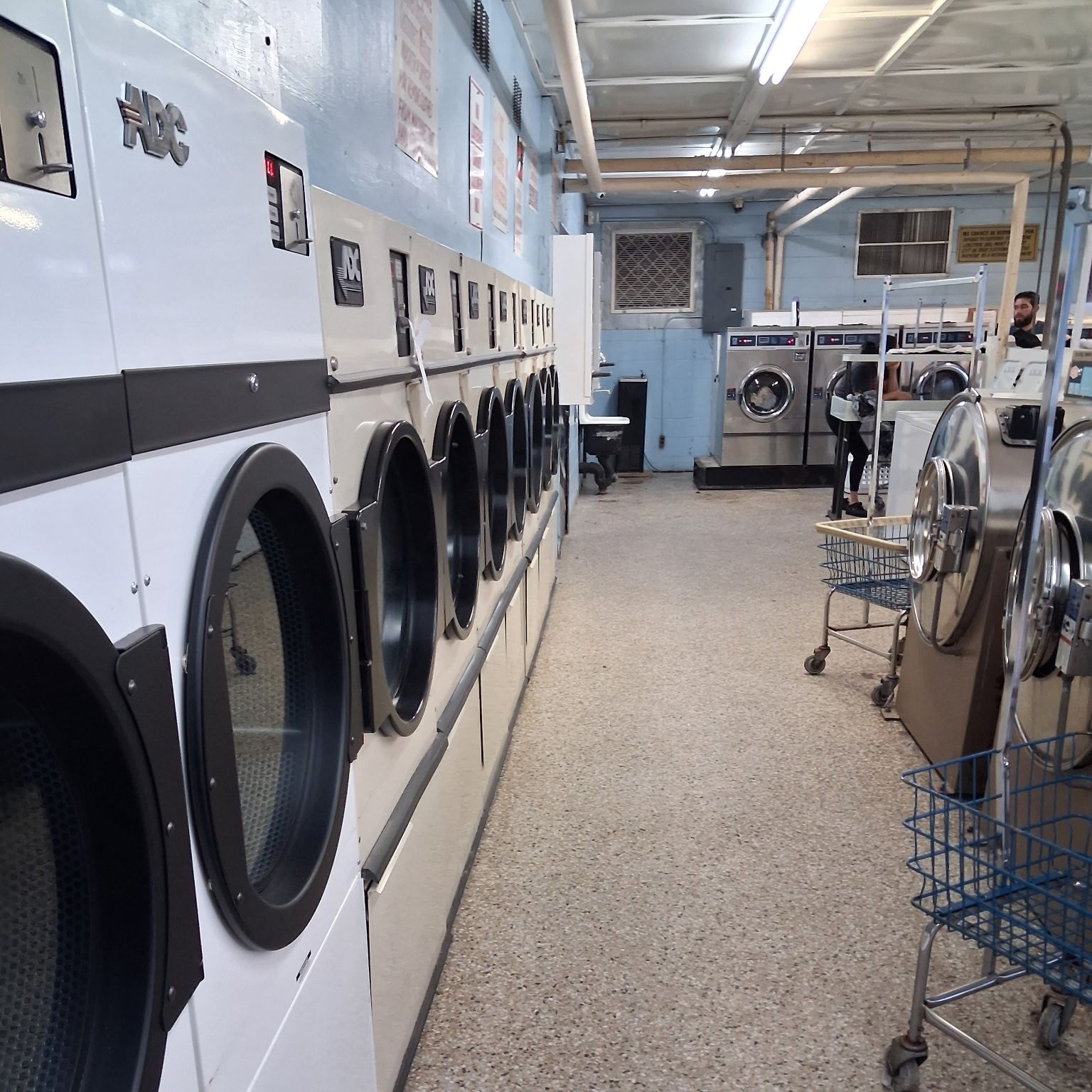 Shared laundry room after cleaning, with the floor mopped and carts returned to the wall