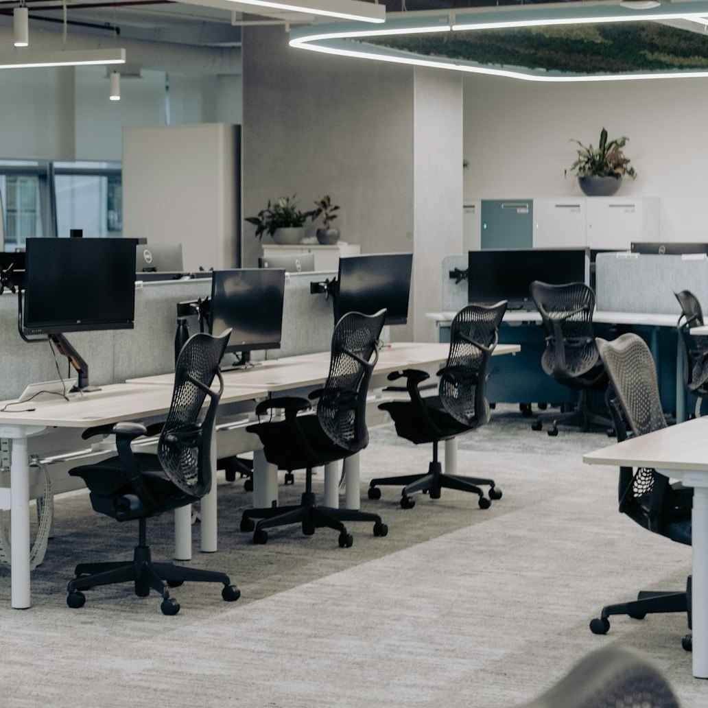 Open-plan desks with mesh chairs and monitors cleaned between shifts