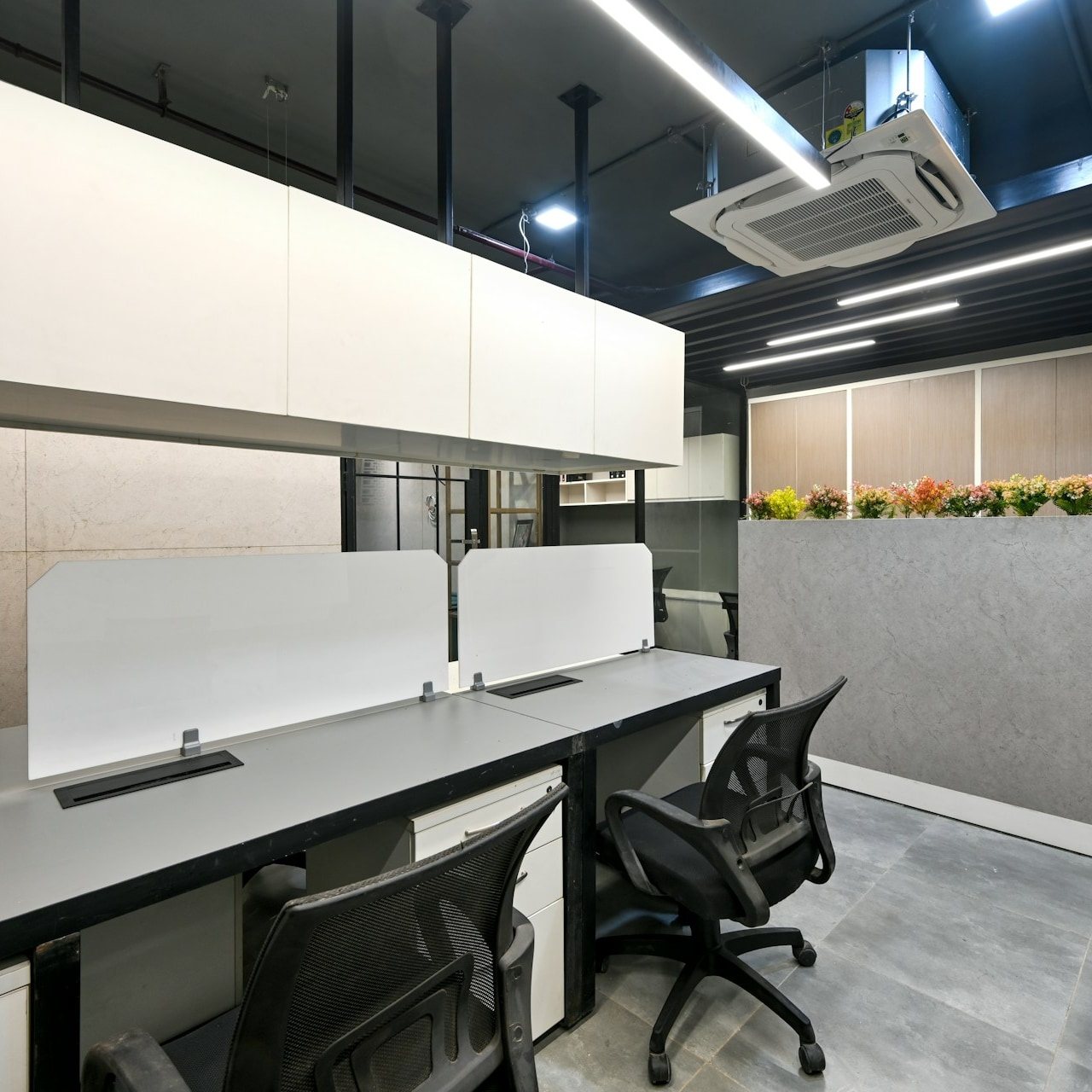 Office workstations with overhead cabinets and a marble partition wall