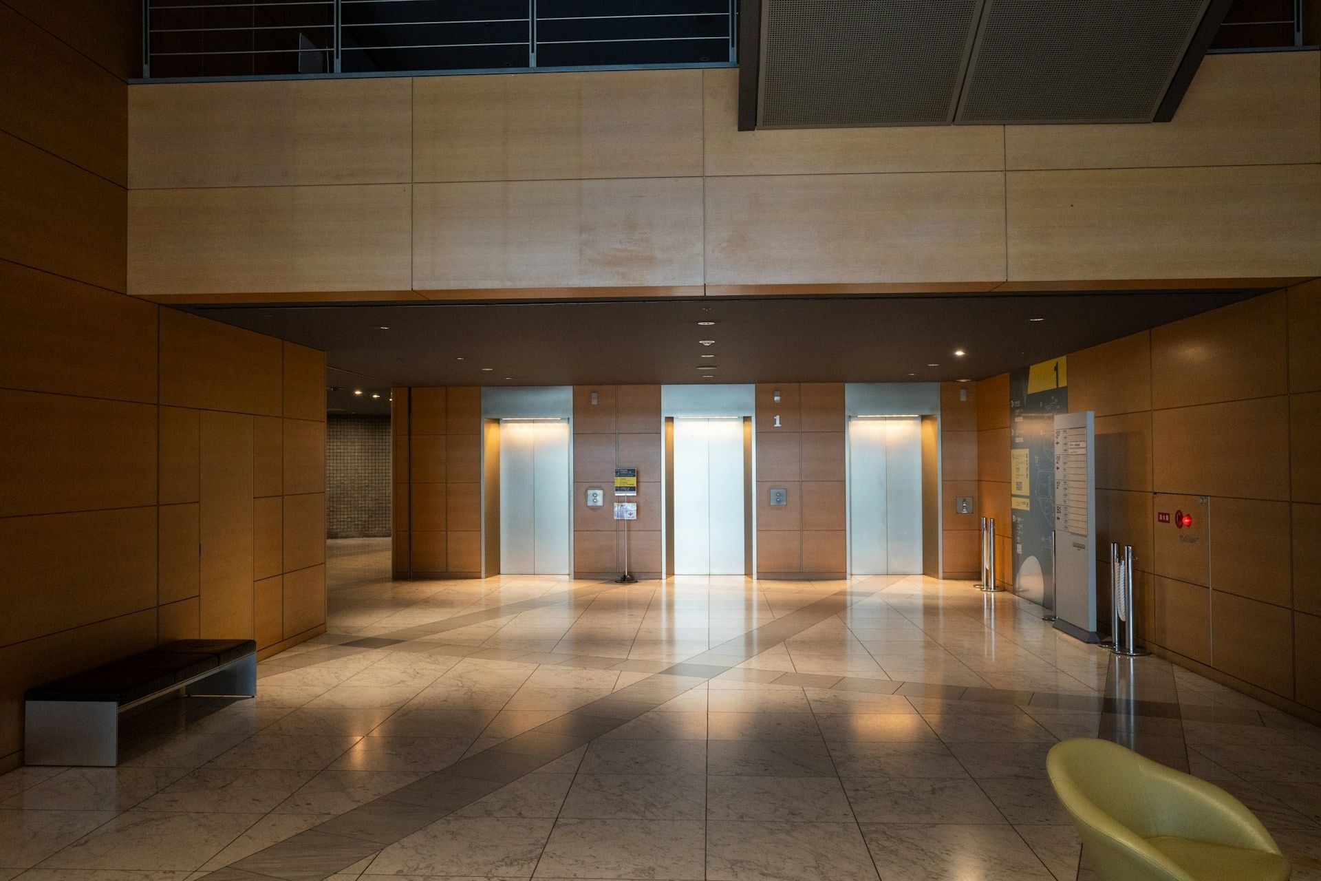 Elevator lobby with wood-panelled walls and a polished stone floor