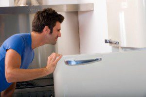 A man deep cleaning the refrigerator